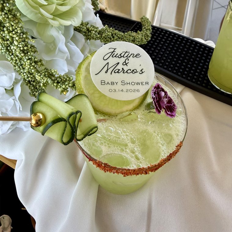 Cucumber cocktail with a chili rim, ribboned cucumber garnish and a custom baby shower topper